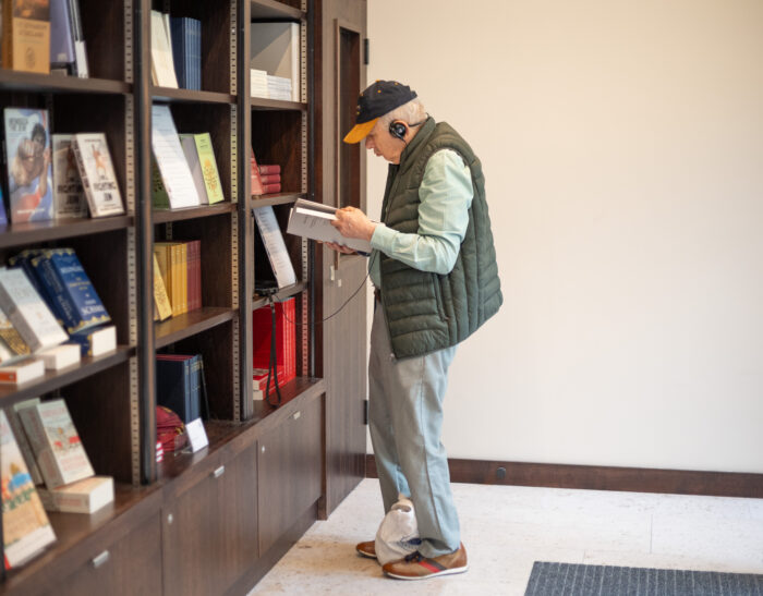 Man browsing shop shelves, holding a book